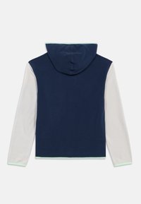 Navy blue hooded jacket with light gray long sleeves and mint green trim on cuffs, hem, and hood edge, shown from the back.