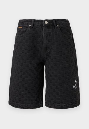 Fekete térdig érő rövidnadrág texturált kockás mintával, elöl gombbal, zsebekkel, valamint a jobb lábszáron kis fehér csillag- és szikra mintákkal.