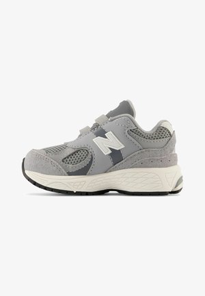 Gray athletic shoe with a mesh upper, suede accents, adjustable straps, and a cushioned sole with textured tread for grip.