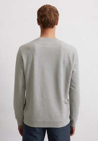 Grijze sweatshirt met lange mouwen, een geribbelde halslijn en zoom, en minimale stikseldetails. De stof lijkt zacht en lichtjes textuur te hebben.