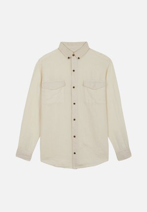 Camisa beige de manga larga con botones, dos bolsillos en el pecho y cuello abotonado, mostrada sobre fondo blanco.