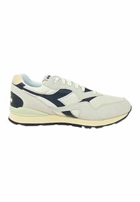 Sneaker beige in suede con accenti neri, pannelli in rete e suola leggera. Presentano lacci, punta perforata e un logo sul retro.