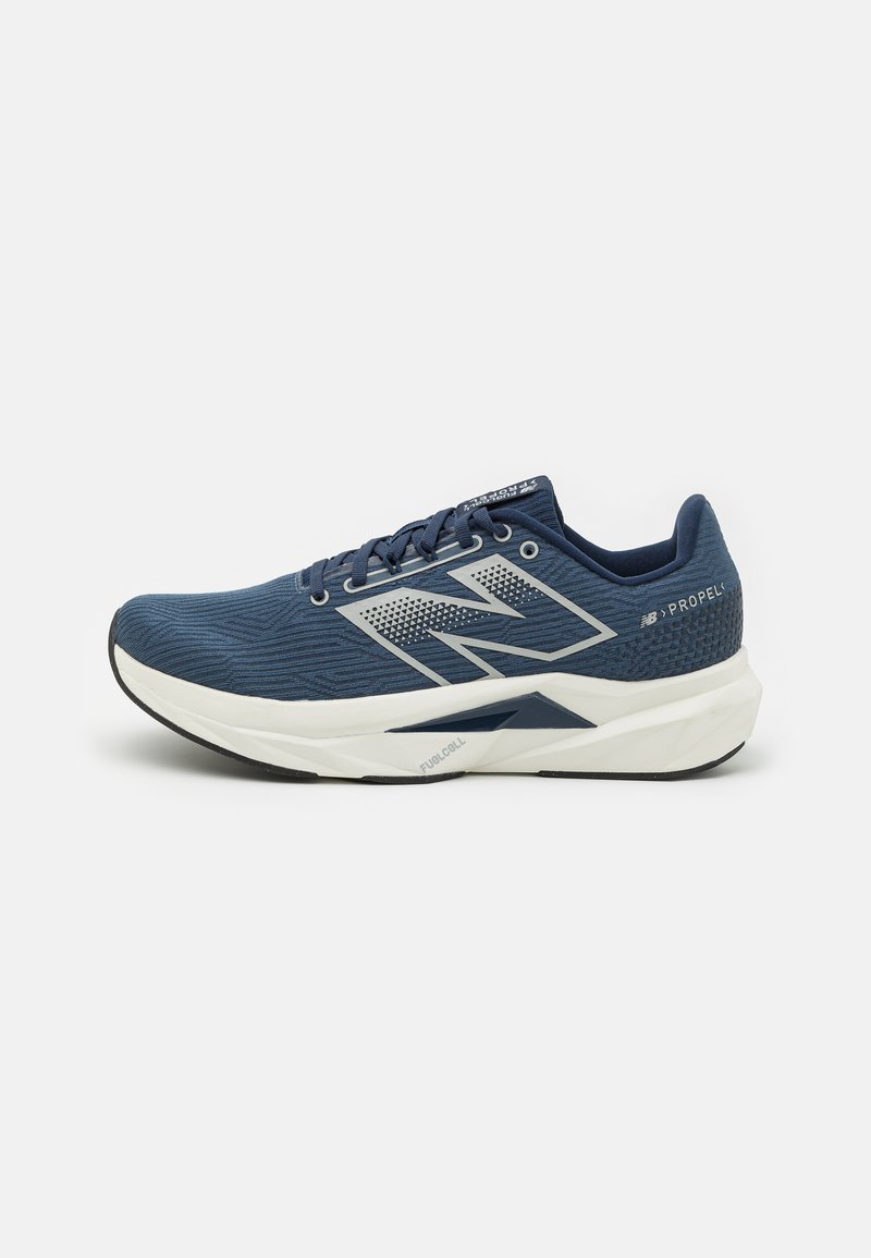 Baskets de sport navy avec tige en mesh texturé, semelle intermédiaire blanche et semelle extérieure en caoutchouc noir. Présente un logo bien visible et des détails perforés.