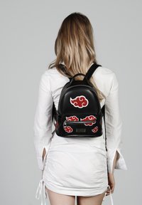 Sac à dos en cuir noir avec des motifs de nuages rouges, forme arrondie, bretelles doubles et une poche zippée à l'avant. Accents de surface texturée.