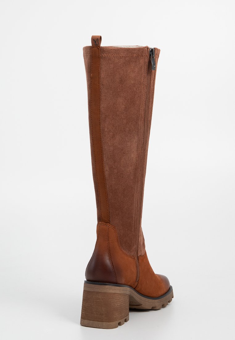 Bota alta de ante marrón con un acabado texturizado, puntera redonda, cremallera lateral y un tacón de madera grueso.