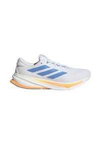 Zapatilla de running blanca con tres rayas azules, acentos en la suela de color naranja y amarillo, y texto "Dreamstrike" en la entresuela.