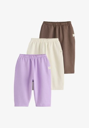 Tre par elastiske taljeshorts i brun, beige og lavendel, arrangeret overlappende på hvid baggrund.