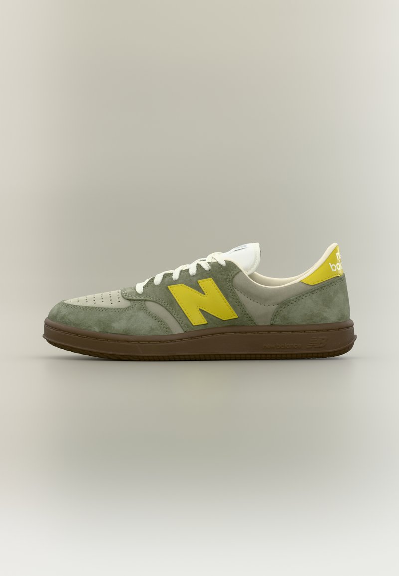 Baskets basses New Balance en daim vert et beige avec des accents de logo jaunes et une semelle marron, présentées de profil sur un fond neutre.