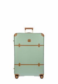 Maleta rígida color verde menta con detalles en cuero marrón, doble asa y cuatro ruedas para una fácil movilidad. Correas horizontales en la parte frontal.