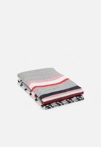 Serviette rayée multicolore ; gris avec des accents rose, rouge et noir. Texture douce, pliée proprement avec un motif à carreaux sur le côté verso.