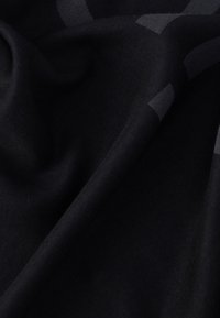 Fekete, puha szövet texturált mintával, mélység és dimenzió érdekében különböző fekete árnyalatokkal. Simán omló, könnyű anyag.