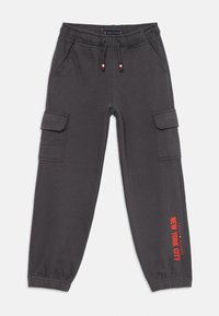 Mörkgrå cargobyxor i sweatpants-stil med elastisk midja och muddar, sidofickor, dragsnören med röd-vit-svarta ändar och röd text "New York City" längs benet.