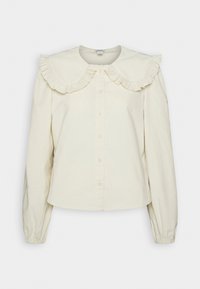 Blouse à manches longues crème avec un grand col froncé et une fermeture à boutons sur le devant, fabriquée à partir d'un tissu texturé doux.