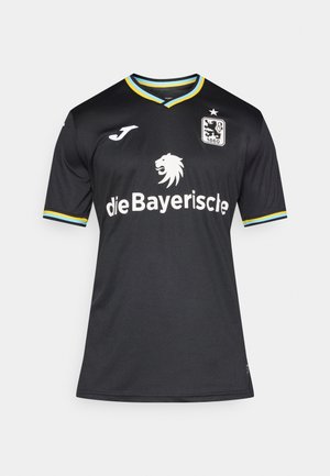 Camiseta de fútbol negra con mangas cortas, cuello en V, detalles en azul y amarillo en el cuello y las mangas, con un emblema de león y texto de patrocinador.