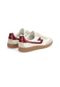 Beige sneakers with red accents, smooth leather and suede materials, round laces, rubber sole, and logo on heel. Low-top design.