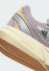 Lagana atletska cipela s gornjim dijelom od svijetloplavog mrežastog materijala, srebrnim i žutim akcentima, te teksturiranim gumenim potplatom s oznakom "LIGHTSTRIKE".