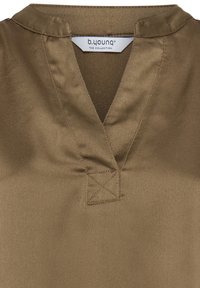 T-shirt marron à col en V avec une texture douce et un détail de couture carrée cousue sous le col, avec une étiquette de la marque b.young à l'intérieur de l'encolure.