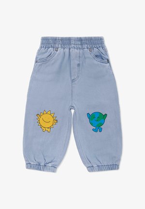 Pantalon en denim bleu clair avec taille élastique ; présente des graphismes jaunes de soleil et verts de la Terre sur les jambes ; chevilles fuselées.