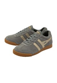 Sneaker in suede grigio con strisce grigie chiare e suola in gomma color cuoio. Presentano lacci e il marchio "Gola" in oro sul lato e sulla linguetta.