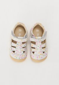 Barnehage-sandaler med hvit bunn, flerfarget blomsterdesign, åpen stile og lysebeige gummisåler. Justerbare borrelåser. Størrelse 19.