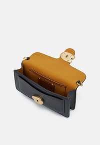 COACH POLISHED PEBBLE TABBY WRISTLET - Pochette - black