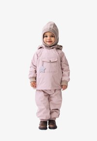 Lichtroze waterdichte jas met een voorzak en sterdetail, gecombineerd met bijpassende broek en een beige gebreide muts. Bruine schoenen maken de outfit compleet.