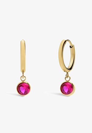 Gouden creolen met ronde, facette dieproze edelsteen hanger aan elke creool, op een witte achtergrond.