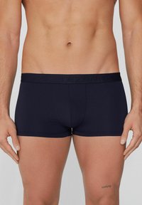 Námorně modré boxerky s hladkým povrchem, elastickým pasem s vyvýšeným logem a přiléhavým střihem.
