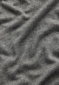 Tessuto lavorato a maglia grigio con una texture liscia, caratterizzato da lievi variazioni di tonalità e da un sottile motivo a trama orizzontale.