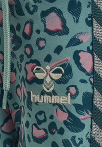 Turkosa leggings med ett leopardmönster i rosa och marinblått. Har en broderad logotyp och texturerade sidopaneler. Mjuk tygkänsla.