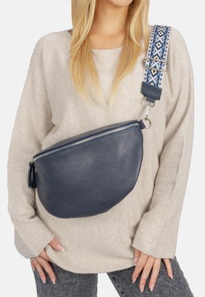 Navy-blaues Leder-Crossbody-Tasche mit runder Form, ausgestattet mit einem silbernen Reißverschluss und einem dekorativen, gemusterten Tragegurt in Creme- und Blautönen.
