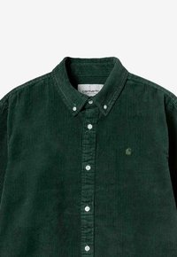 Groene corduroy langarm overhemd met knoopsluiting en button-down kraag, voorzien van een klein geborduurd logo op de linkerborst.