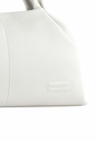 Gros plan sur un sac à main en cuir texturé blanc avec des coutures cousues et un petit patch en relief portant le nom de la marque "bugatti".