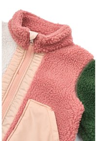 Ζακέτα από φλις με ψηλό ροζ γιακά, μπεζ φερμουάρ και πάνελ από ροζ, λευκό και πράσινο υφασμάτινο ύφασμα με υφή· περιλαμβάνει μπροστινή τσέπη.