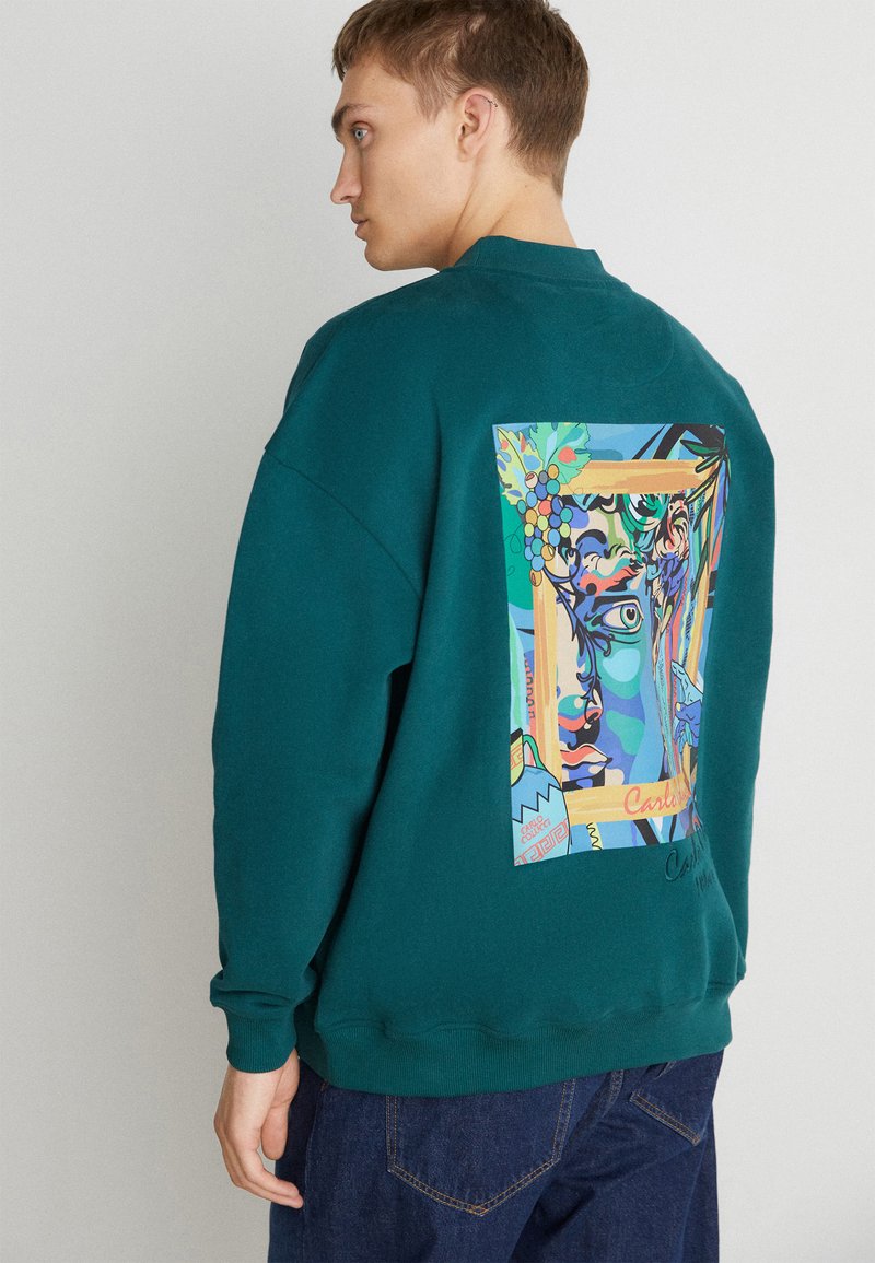 Teal sweatshirt met een kleurrijke grafische print op de achterkant, die abstracte gezichten, bladeren en druiven toont. Casual pasvorm, geribde manchetten.