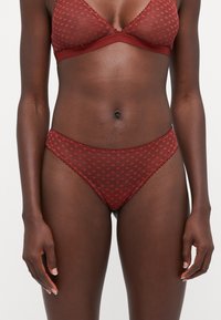 Burgunderfarbenes Lingerie-Set mit einem durchsichtigen, verstellbaren BH mit Herzmustern und passenden durchsichtigen Slips mit gewelltem Saum.