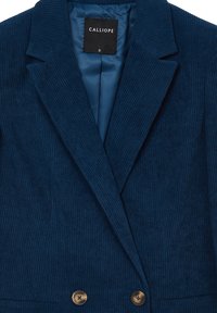 Blazer in velluto a coste navy con revers a punta, chiusura a doppio bottone e tessuto testurizzato. Presenta una fodera in raso e etichetta del brand. Taglia: S.