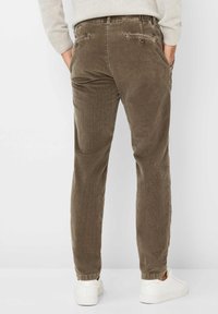 Pantaloni in corduroy marroni con una vestibilità rilassata, caratterizzati da una superficie testurizzata, tasche sul retro e una vita con cordoncino.