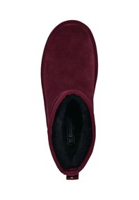 Burgunderfarbene Knöchelschuhe aus weichem Wildleder mit einem schwarzen, plüschigen Innenfutter und einer Zuglasche an der Rückseite, die ein abgerundetes Design der Zehenpartie aufweist.