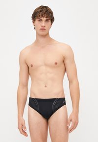 Slip da nuoto nero con una texture liscia, caratterizzati da linee di accento grigie e un design aderente. Il materiale sembra elastico e resistente all'acqua.