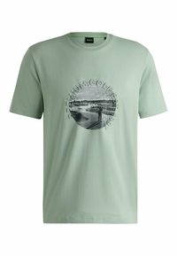 Light green cotton t-shirt featuring a circular black and white graphic with text "Premium Golf Est. 1992" and a round neckline.