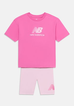 T-shirt New Balance a maniche corte di un rosa acceso abbinata a shorts rosa chiaro con logo New Balance rosa.