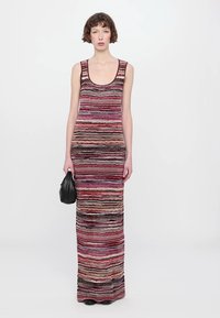 Striped knit maxi dress in pink, purple, and black. Features a scoop neckline and fitted silhouette. Smooth texture, sleeveless design.