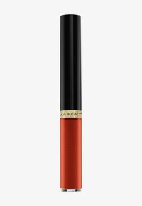 Rossetto liquido in un tubo trasparente, con tappo nero e dettaglio dorato. Il colore è un arancio-rosso brillante e scintillante.