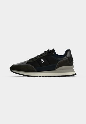 Baskets de sport noires et gris foncé avec doublure blanche au niveau du col, logo blanc sur le côté, semelle superposée blanche et beige, et semelle extérieure noire.