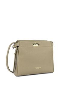 Beige leather crossbody bag with textured surface, gold hardware, and a flap closure. Includes an adjustable strap and subtle branding.