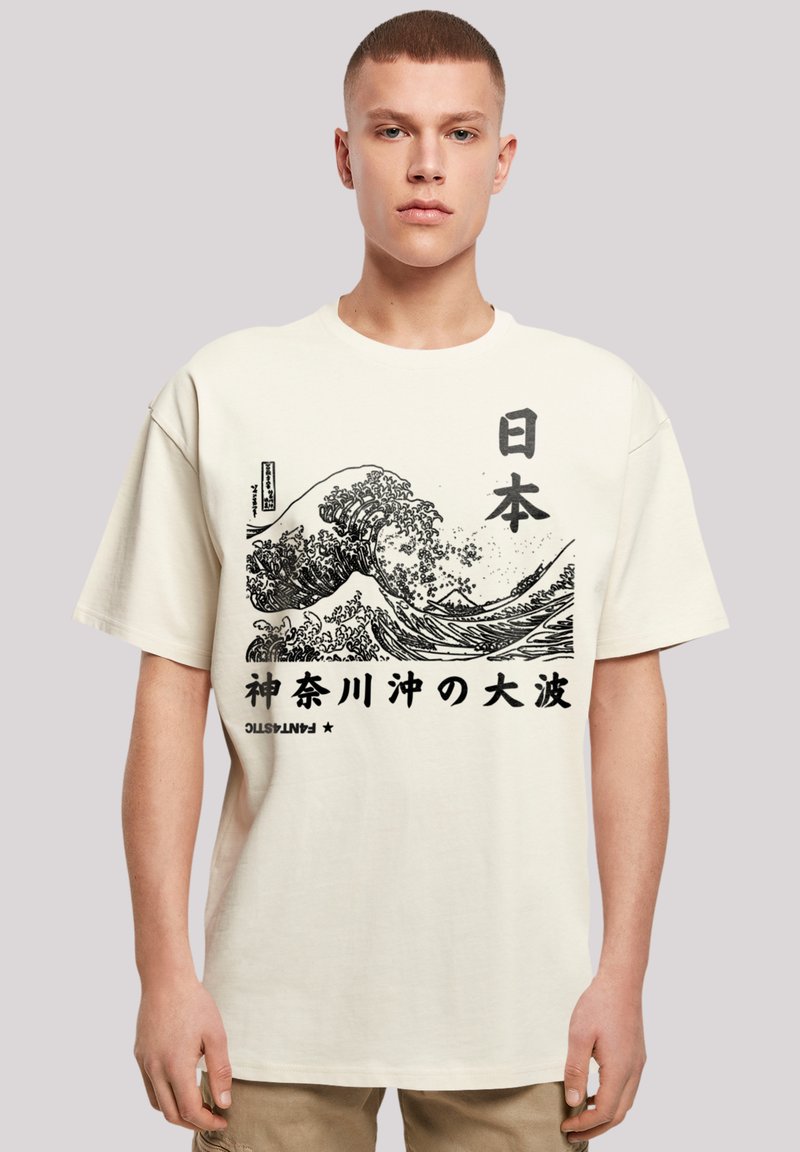 Cream-colored cotton t-shirt featuring a black wave graphic and Japanese text. Short sleeves and a relaxed fit. No visible logos.