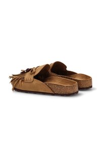 Las sandalias de ante marrón de tipo slip-on cuentan con un acento de flecos, suela de corcho y un interior suave. El diseño incluye una punta redondeada y un tacón plano.