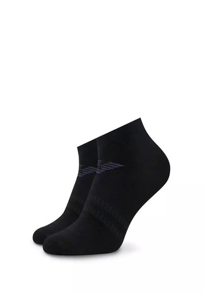 Chaussettes noires pour la cheville en matériau doux, dotées d'un bord côtelé et d'un discret motif rayé bleu. Forme épurée et texture lisse.