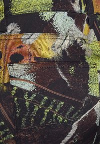 Gestructureerde stof met een levendig, multicolor abstract patroon in groen, geel en bruin; bevat een achterzak aan de rechterkant.